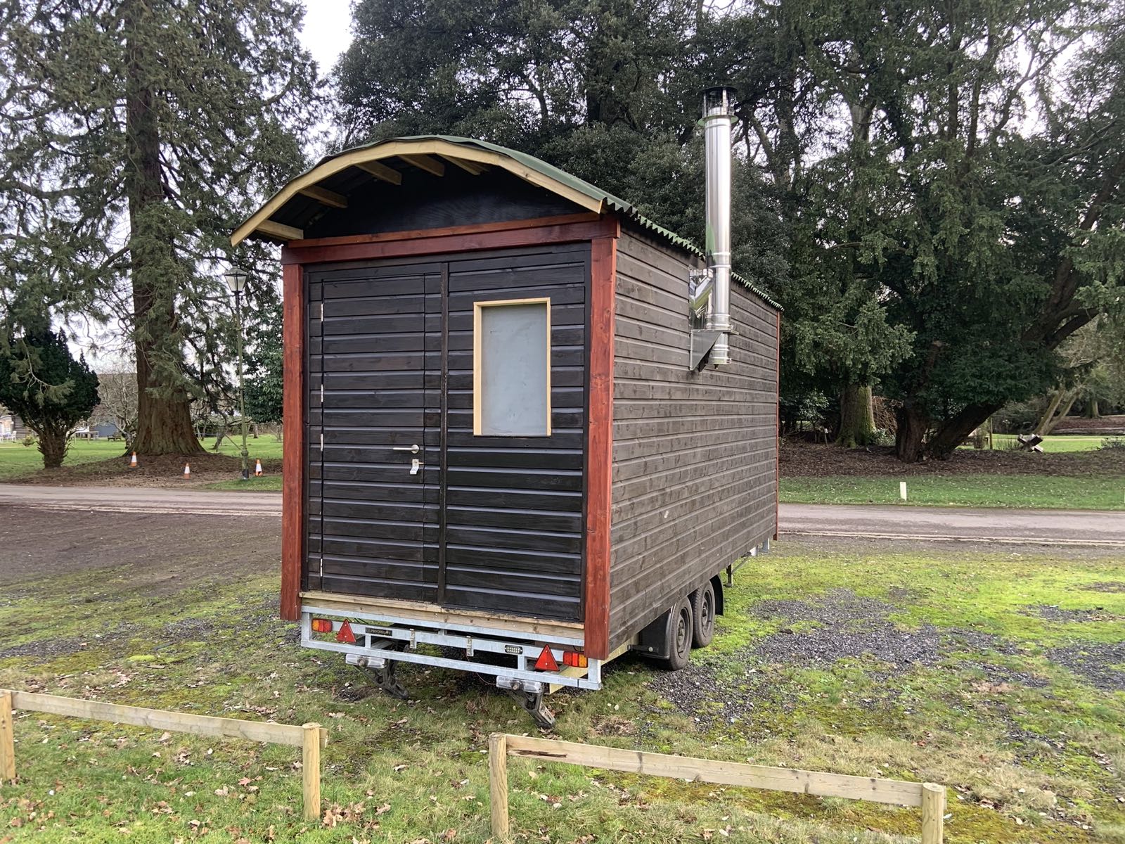 The wood-fired shepherd's hut sauna with its chimney, set among trees