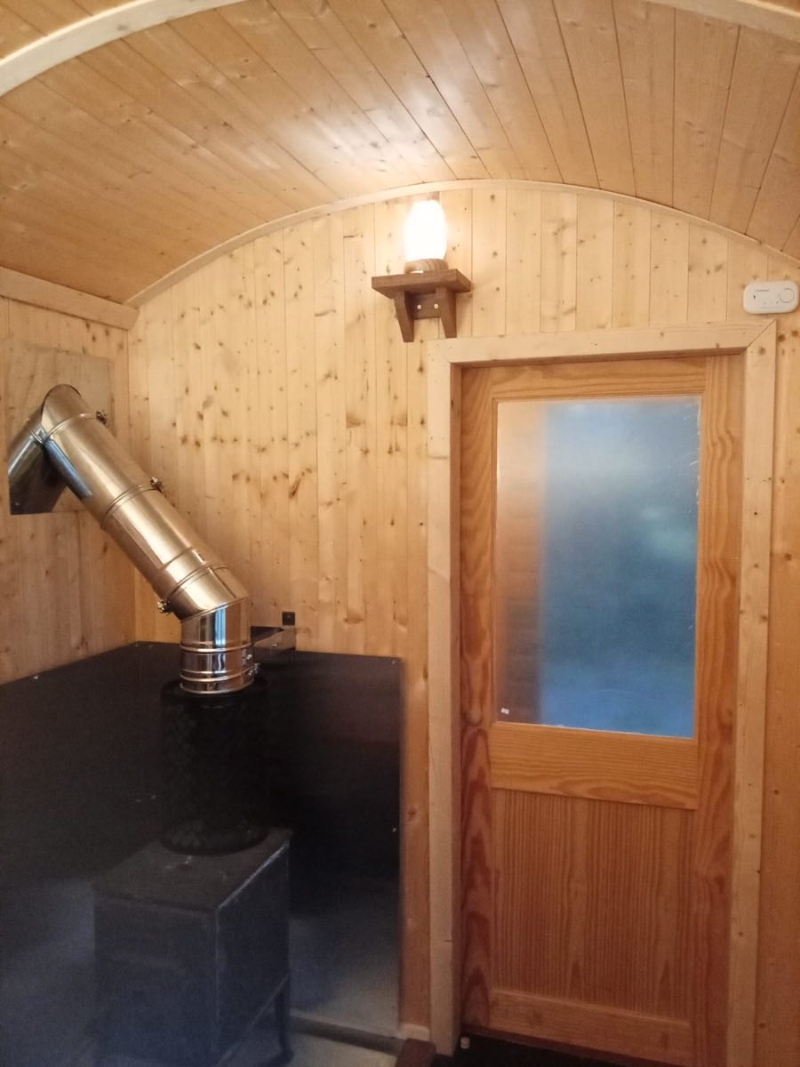 The wood-burning stove and flue inside the sauna